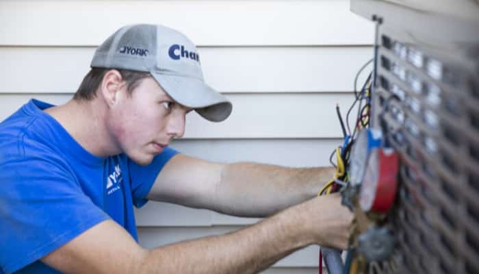 Tech maintaining an HVAC